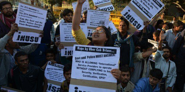 Indian residents hold placards and chant slogans as they take part in a protest against the alleged rape of a passenger by a driver working for the Uber taxi company in New Delhi on December 7, 2014. An Uber taxi driver allegedly raped a 25-year-old passenger in the Indian capital before threatening to kill her, police said December 7, in a blow to the company's safety-conscious image. AFP PHOTO/STR (Photo credit should read STRDEL/AFP/Getty Images)