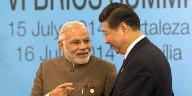 India's Prime Minister Narendra Modi, left, talks with China's President Xi Jinping, as South Africa's President Jacob Zuma looks on after they took their group photo for the BRICS summit in Fortaleza, Brazil, Tuesday, July 15, 2014. The leaders of the BRICS nations, Brazil, Russia, India, China and South Africa, are expected to officially create a bailout and development fund worth $100 billion. It's meant to be an alternative to the World Bank and the International Monetary Fund, which are seen as being dominated by the U.S. and Europe. (AP Photo/Silvia Izquierdo)