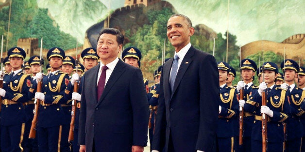 U.S. President Barack Obama, right, smiles after a group of children waved flags and flowers to cheer him during a welcome ceremony with Chinese President Xi Jinping at the Great Hall of the People in Beijing, China Wednesday, Nov. 12, 2014. When Xi Jinping took the reins of a booming China two years ago, President Barack Obama saw an opportunity to remake America's relationship with the Asian power. But even after Obama's unusually robust efforts to forge personal ties with Xi, the two leaders are meeting in Beijing amid significant tensions, both old and new. (AP Photo/Andy Wong)