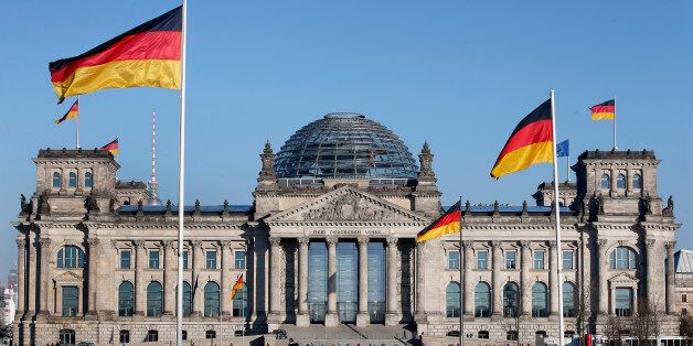German flags wave in front of the Reichstag building, host of the German Federal Parliament Bundestag, in Berlin, Germany, Tuesday, March 5, 2013. (AP Photo/Michael Sohn)
