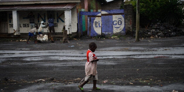 A young Congolese walks through the rain in the town of Sake, west of Goma, in the east of the Democratic Republic of Congo on November 28, 2012. The government accused rebels today of widespread looting in Goma as the fighters began pulling out of the strategic eastern city following diplomatic mediation to prevent the conflict spreading across the volatile region. AFP PHOTO/PHIL MOORE (Photo credit should read PHIL MOORE/AFP/Getty Images)