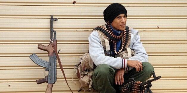 A fighter loyal to Khalifa Haftar, a retired general and former chief of staff for Moamer Kadhafi, takes a break as they fight alongside the Libyan army in clashes with Islamist gunmen in the eastern Libyan city of Benghazi on December 16, 2014. Battles between the coalition of the army and forces loyal to Haftar against militia gunmen took place in several parts of the city but the army reportedly secured the area south-west of the city centre. AFP PHOTO / ABDULLAH DOMA (Photo credit should read ABDULLAH DOMA/AFP/Getty Images)