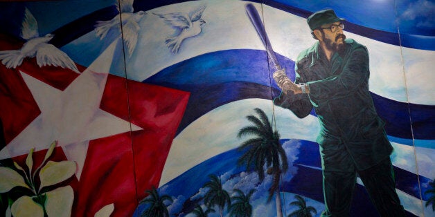 A mural of Fidel Castro playing baseball decorates a wall at the Latin American baseball stadium in Havana, Cuba, late Thursday, Dec. 18, 2014. The announcement on Wednesday that the U.S. plans to restore diplomatic ties with the Caribbean nation could usher in a new era in U.S.-Cuba baseball relations, which were strained after the Castro revolution and the U.S.-led economic embargo. Castro banned professional sports in Cuba in 1962. (AP Photo/Ramon Espinosa)