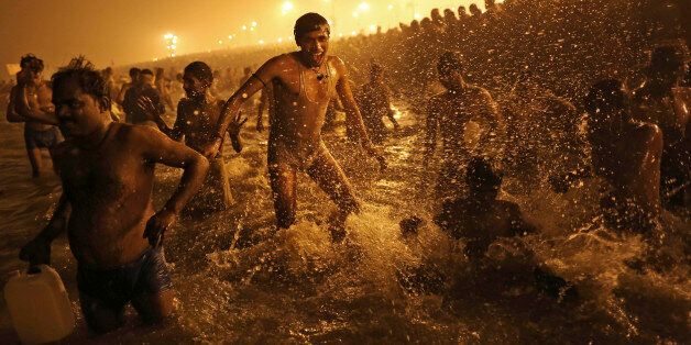 An Indian Hindu man jumps up and down in the water as he takes a dip at Sangam, the confluence of the rivers Ganges, Yamuna and mythical Saraswati, during the royal bath on Makar Sankranti at the start of the Maha Kumbh Mela in Allahabad, India, Monday, Jan. 14, 2013. Millions of Hindu pilgrims are expected to take part in the large religious congregation that lasts more than 50 days on the banks of Sangam during the Maha Kumbh Mela in January 2013, which falls every 12th year. (AP Photo/Kevin Frayer)
