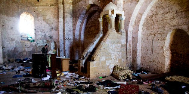This photo made on Thursday, May 1, 2014, shows belongings of Syrian rebels inside a chapel at Crac des Chevaliers, the world's best preserved medieval Crusader castle, in Syria. The village was destroyed in fighting between the government and rebel forces while the castle, listed as a UNESCO world heritage site, also has been damaged over the past two years. (AP Photo/Dusan Vranic)