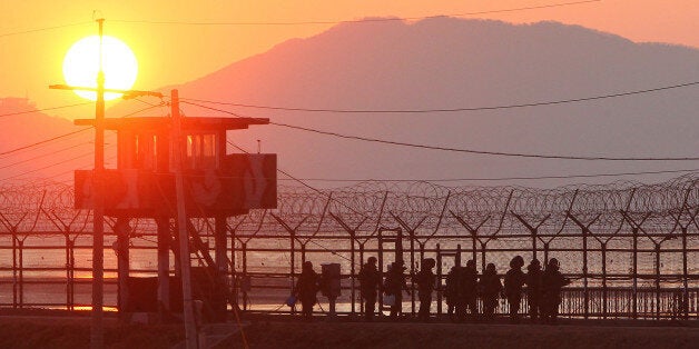 South Korean soldiers patrol along iron fence in Paju near the Demilitarized Zone (DMZ) dividing the two Koreas on December 19, 2011. North Korean leader Kim Jong-Il has died aged 69 of a heart attack, state media announced plunging the nuclear-armed, famine-ridden and deeply isolated nation into a second dynastic succession. REPUBLIC OF KOREA OUT NO ARCHIVES NO INTERNET RESTRICTED TO SUBSCRIPTION USE AFP PHOTO/YONHAP (Photo credit should read YONHAP/AFP/Getty Images)