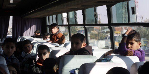 Palestinian children wait on a bus at Erez crossing in Beit Hanun in the north of the Gaza Strip on December 28, 2014, before being prevented by Hamas from entering Israeli territory in a pre-arranged week-long trip, organisers and officials said. The visit was planned for 37 children whose parents were killed by Israel in the Gaza Strip in July and August this year. It was organised by an Israeli kibbutz group and local Arab-Israeli officials. AFP PHOTO/MAHMUD HAMS (Photo credit should read MAHMUD HAMS/AFP/Getty Images)