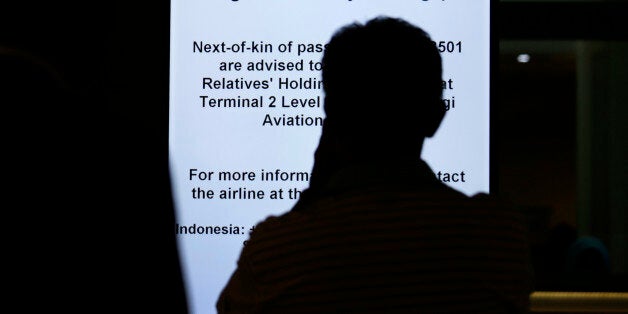 A man is silhouetted against an electronic sign board instructing relatives and next-of-kin to gather at a holding area at the Changi International Airport where AirAsia Flight 8501 from Surabaya, Indonesia was scheduled to land, Sunday, Dec. 28, 2014 in Singapore. The AirAsia plane disappeared Sunday while flying over the Java Sea after taking off from Indonesia's second-largest city for Singapore. (AP Photo/Wong Maye-E)