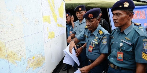 SURABAYA, INDONESIA - DECEMBER 29: Indonesian naval officers prepare the operational air navigation map during the investigation of missing AirAsia flight QZ8501 outside the crisis center of Juanda International Airport Surabaya on December 29, 2014 in Surabaya, Indonesia. AirAsia announced that flight QZ8501 from Surabaya to Singapore, with 162 people on board, lost contact with air traffic control at 07:24 a.m. local time on December 28. (Photo by Robertus Pudyanto/Getty Images)