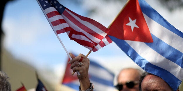 MIAMI, FL - DECEMBER 20: A protester holds an American flag and a Cuban one as she joins with others opposed to U.S. Presiden