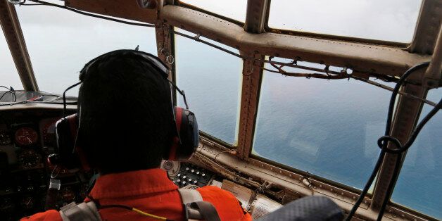 A crew of an Indonesian Air Force C-130 airplane of the 31st Air Squadron scans the horizon during a search operation for the missing AirAsia flight 8501 jetliner over the waters of Karimata Strait in Indonesia, Monday, Dec. 29, 2014. Search planes and ships from several countries on Monday were scouring Indonesian waters over which an AirAsia jet disappeared, more than a day into the region's latest aviation mystery. AirAsia Flight 8501 vanished Sunday in airspace thick with storm clouds on its way from Surabaya, Indonesia, to Singapore. (AP Photo/Dita Alangkara)