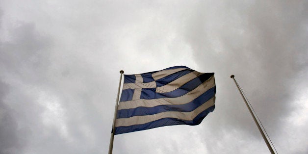 A Greek national flag flies from a pole beneath stormy skies outside the Hellenic Stock Exchange in Athens, Greece, on Wednes