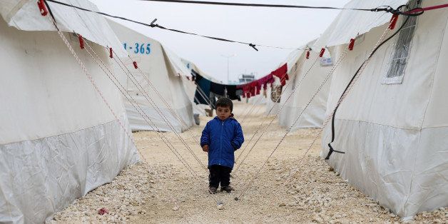 A Syrian refugee boy who fled violence in Syrian city of Ayn al-Arab or Kobani seen outside his tent in Turkeyâs newly set-up camp in the border town of Suruc, Turkey, Friday, Jan. 30, 2015. The 35,000 people capacity camp is the biggest refugee camp in Turkey. About 200,000 people arrived in Turkey since the start of fighting between Kurdish militia and Islamic State militants mid-September, 2014. (AP Photo/Emrah Gurel)
