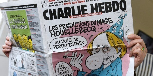 A person reads the latest issue of the French satirical newspaper Charlie Hebdo in Paris on January 7, 2015, after gunmen armed with Kalashnikovs and a rocket-launcher opened fire in the offices of the weekly in Paris, killing at least 11. AFP PHOTO / BERTRAND GUAY (Photo credit should read BERTRAND GUAY/AFP/Getty Images)