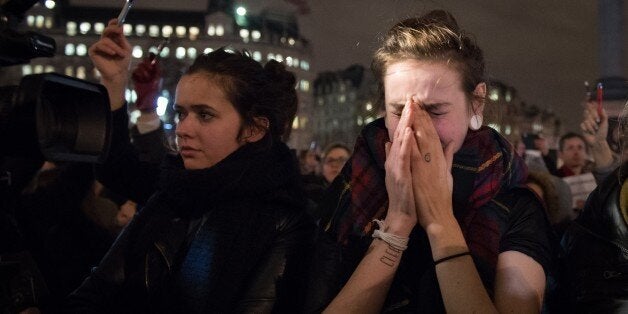 Pens are held in the air as people gather in Trafalgar Square in central London to show their respect for the twelve people k