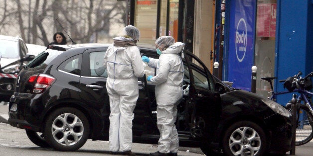 Forensic experts examine the car believed to have been used as the escape vehicle by gunmen who attacked the French satirical newspaper Charlie Hebdo's office, in Paris, France, Wednesday, Jan. 7, 2015. Masked gunmen stormed the offices of a French satirical newspaper Wednesday, killing at least 11 people before escaping, police and a witness said. The weekly has previously drawn condemnation from Muslims. (AP Photo)