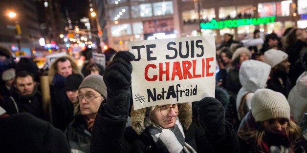 A mourner holds a sign that reads "I AM CHARLIE" in French during a rally in support of Charlie Hebdo, a French satirical weekly newspaper that fell victim to an terrorist attack, Wednesday, Jan. 7, 2015, at Union Square in New York. French officials say 12 people were killed when masked gunmen stormed the Paris offices of the periodical that had caricatured the Prophet Muhammad. (AP Photo/John Minchillo)