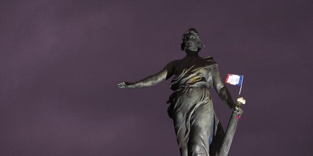 A French national flag and flowers remain hung at the statue named 'Le triomphe de la Republique' (Republic Triumph) by Frenc