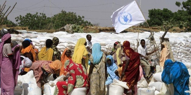 TO GO WITH AFP STORY BY ABDELMONEIM ABU IDRIS ALI Sudanese displaced women collect humanitarian aid supplies provided by the UN's World Food Program, on November 6, 2014, in the Kalma camp for internally displaced people (IDP) located east of Nyala city in Sudan's Darfur. The camp hosts 163,000 residents who fled the conflict in Darfur which has killed 300,000 people and displaced two million. AFP PHOTO/ASHRAF SHAZLY (Photo credit should read ASHRAF SHAZLY/AFP/Getty Images)