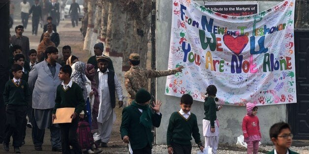 Pakistani parents leave the Army Public School with their children after it was reopened following an attack there by Taliban militants in Peshawar on January 12, 2015. Child survivors of Pakistan's worst ever terrorist attack returned to the school where Taliban militants massacred their classmates January 12, with both the students and their parents expressing a mixture of defiance and apprehension. The December 16, 2014 attack on the Army Public School in Peshawar by a group of gunmen and suicide bombers claimed the lives of 150 people, mostly children, and prompted a bout of national soul-searching even in a country used to high levels of militancy. AFP PHOTO / A MAJEED (Photo credit should read A Majeed/AFP/Getty Images)