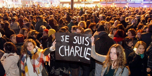 Demonstrators hold a banner reading " I am Charlie", during a demonstration at the Old Port of Marseille, southern France, Wednesday, Jan. 7, 2015, after a shooting at a French satirical newspaper in Paris. Three masked gunmen shouting "Allahu akbar!" stormed the Paris offices of a satirical newspaper, Charlie Hebdo, Wednesday, killing 12 people, including its editor, before escaping in a car. It was France's deadliest postwar terrorist attack. (AP Photo/Claude Paris)