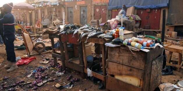 An ecavuated fish stand is seen as Nigerian security inspect the site of a bomb blast at the Jos Terminus Market, on December