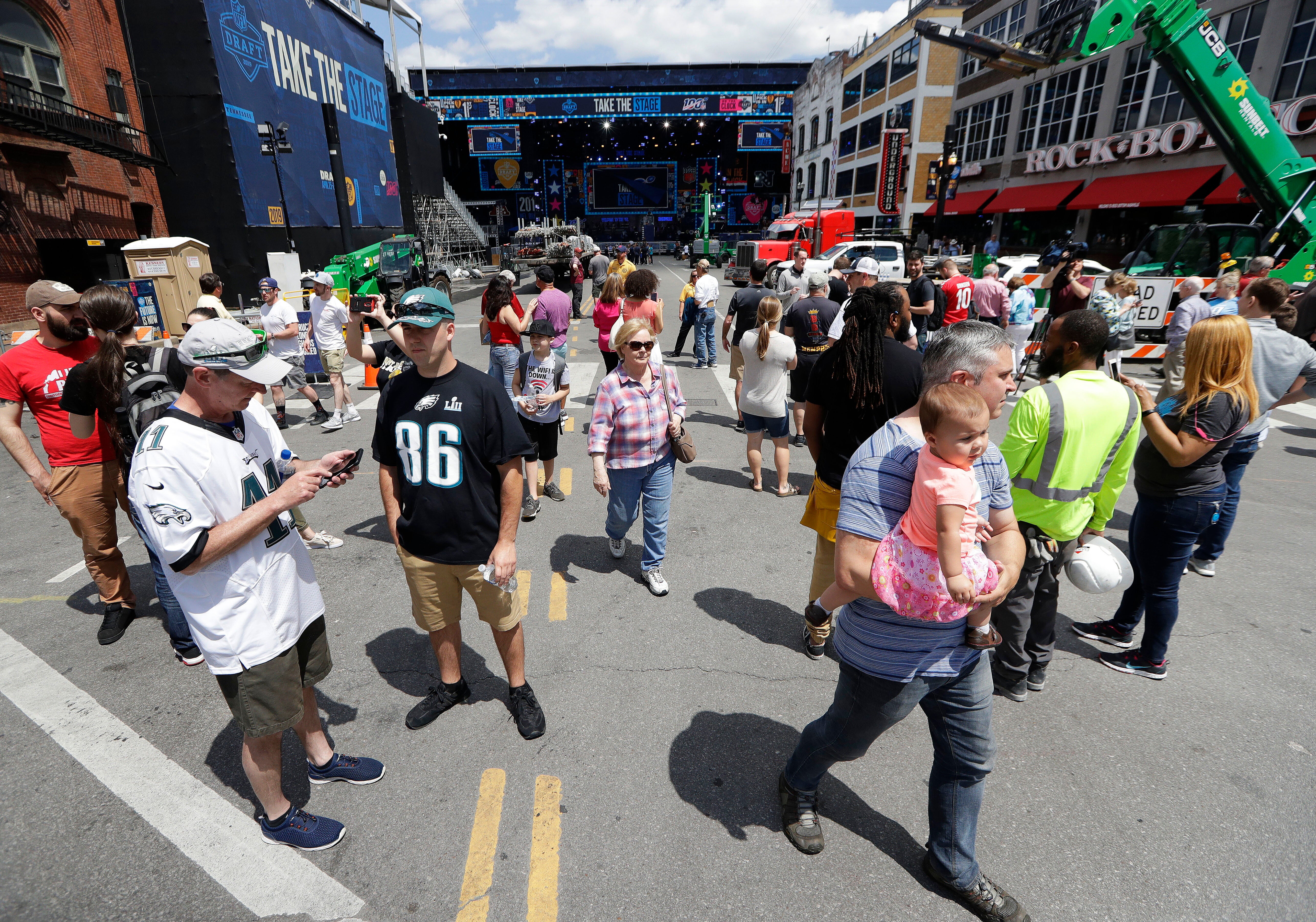 Onlookers watch the progress of the NFL stage being built ahead of the first-round NFL Draft in Nashville, Tenn. (AP Photo)