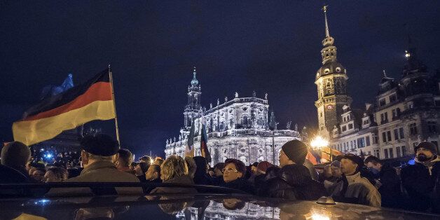 Participants of a rally called 'Patriotic Europeans against the Islamization of the West' (PEGIDA) reflect in a car roof during a demonstration entitled âChristmas With Pegidaâ in front of the Dresden Cathedral, or the Cathedral of the Holy Trinity, center, in Dresden, eastern Germany, Monday, Dec. 22, 2014. For the past ten weeks, activists protesting Germanyâs immigration policy and the spread of Islam in the West have been marching each Monday. (AP Photo/Jens Meyer)