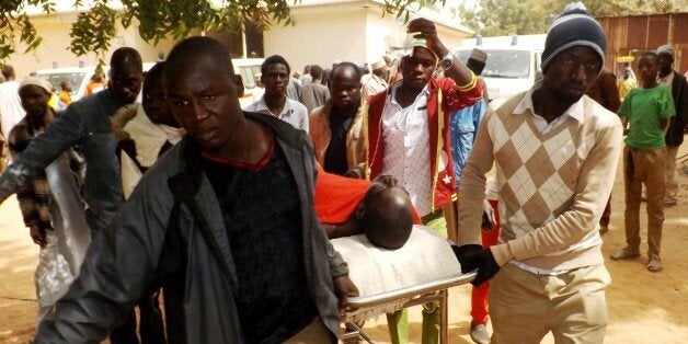 A man injured in a suicide blast is transported at the General Hospital in northeast Nigerian town of Potiskum on January 12, 2015. Four people were killed and 46 injured when two female suicide bombers detonated their explosives outside a mobile phone market in the town on January 11, 2015. Although no one claimed responsibility the attacks bore the hallmark of Boko Haram Islamists who have been increasingly using female suicide bombers in their armed campaign to establish a hardline Islamic state. Potiskum, the commercial hub of Yobe state has been repeatedly attacked by Boko Haram. AFP PHOTO / Aminu ABUBAKAR (Photo credit should read AMINU ABUBAKAR/AFP/Getty Images)