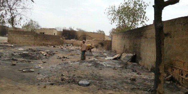 FILE- In this Sunday April. 21, 2013 file photo taken with a mobile phone, a young girl stands amid the burned ruins of Baga, Nigeria. Hundreds of bodies â too many to count â remain strewn in the bush in Nigeria from an Islamic extremist attack that Amnesty International suggested Friday is the "deadliest massacre" in the history of Boko Haram. Mike Omeri, the government spokesman on the insurgency, said fighting continued Friday Jan. 9, 2015 for Baga, a town on the border with Chad where insurgents seized a key military base on Jan. 3 and attacked again on Wednesday. "Security forces have responded rapidly, and have deployed significant military assets and conducted airstrikes against militant targets," Omeri said in a statement. (AP Photo / Haruna Umar file )