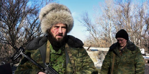 In this Wednesday, Jan. 14, 2015 photo Russian-backed separatist Cossack, stands on guard at the check-point north of Luhansk