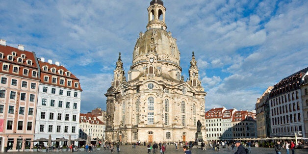 In this picture taken Oct. 16, 2014 people cycle in front of the 18th century Frauenkirche cathedral (Church of Our Lady) in