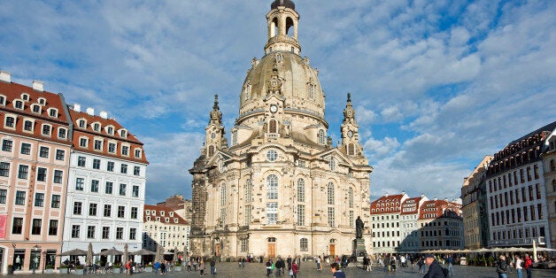 In this picture taken Oct. 16, 2014 people cycle in front of the 18th century Frauenkirche cathedral (Church of Our Lady) in Dresden, Germany. Twenty five years after the fall of the Berlin Wall, the disparities that remain between former West and East Germany are a common theme. Unemployment is higher in the east, disposable incomes are lower and the populations are older as the young move west for better opportunities. But the broad-brush look at unified Germany glosses over some major exceptions as Dresden and Dortmund. (AP Photo/Jens Meyer)