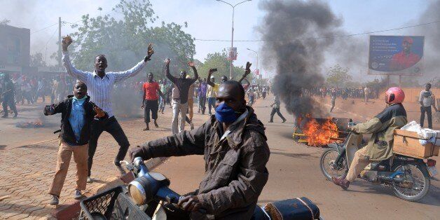 Smoke billows in a street as people demonstrate against French weekly Charlie Hebdo's publication of a cartoon of the Prophet Mohammed near the grand mosque in Niamey, on January 17, 2015. At least 1,000 youths assembled at the grand mosque in the capital Niamey, some of them throwing rocks at police while others burned tyres and chanted 'Allahu Akbar' ('God is Greatest'). The protest came a day after a policeman and three civilians were killed and 45 injured in protests against Charlie Hebdo in Niger's second city of Zinder, which saw three churches ransacked and the French cultural centre burned down.AFP PHOTO / BOUREIMA HAMA (Photo credit should read BOUREIMA HAMA/AFP/Getty Images)