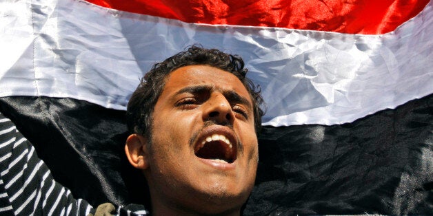 FILE - In this Thursday, Feb. 10, 2011 file photo, a Yemeni demonstrator shouts slogans while raising his national flag during an anti-government protest in Sanaa, Yemen. Yemen's 2011 Arab Spring revolt began with a nucleus of young men and women, a mix of socialists, secularists and moderate Islamists seeking to end autocrat Ali Abdullah Saleh's 33-year rule and transform the poorest Arab nation into a democratic, modern society. In October 2014, nearly four years later, Yemen is in chaos and Shiite rebels have overrun the capital. Saleh is out of power, but remains powerful, with his loyalists infusing the political scene and the military. Attempts at real reform are in disarray. (AP Photo/Hani Mohammed, File)