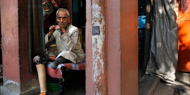 In this Feb. 5, 2014 photo, leprosy patient Satnarayan Singh, 86, sits outside his shop at a leper colony in New Delhi, India. Although India has made great strides against leprosy over the years, the stigma of the disease is as intractable as ever, hindering efforts to eliminate the disease entirely. Worldwide the number of new leprosy patients has dropped from around 10 million in 1991 to around 230,000 last year. Of these, 58 percent were to be found in India, according to the World Health Organization. (AP Photo/Manish Swarup)