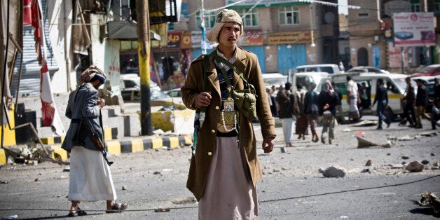 Houthi Shiite Yemeni gather while guarding a street leading to the presidential palace in Sanaa, Yemen, Tuesday, Jan. 20, 2015. Yemen's U.S.-backed leadership came under serious threat Monday as government troops clashed with Shiite rebels near the presidential palace and a key military base in what one official called "a step toward a coup." (AP Photo/Hani Mohammed)