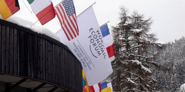 National flags and a flag for the World Economic Forum's (WEF) 2012 annual meeting, centre, sit on the roof of the congress C