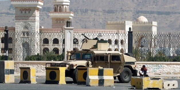 A Shiite Huthi militiaman sits near a tank confiscated from the army in the area around the presidential palace in the capita