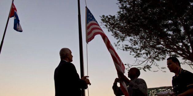 Workers of the hotel Armadores de Santander lower the United States flag along with the rest of the hotel's flags, at sunset in Havana, Cuba, Wednesday, Jan. 21, 2015. Cuba has so far offered a guardedly positive reception to President Barack Obama's loosening of the trade embargo on Cuba, saying it welcomes the full package of new economic ties on offer, but it insists it will maintain its one-party political system and centrally planned economy. (AP Photo/Ramon Espinosa)