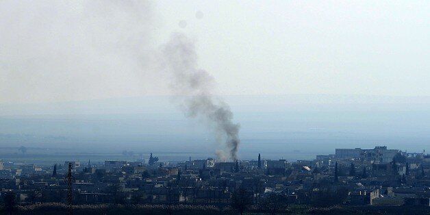 A picture taken on January 26, 2015 in Sanliufra shows smoke billowing from the Syrian town Kobane, also known as Ain al-Arab, following clashes between Kurdish forces and Islamic State (IS) groups. Kurdish fighters have expelled Islamic State group militants from the Syrian border town of Kobane, a monitor and spokesman said today, dealing a key symbolic blow to the jihadists' ambitions. AFP PHOTO / STRINGER (Photo credit should read -/AFP/Getty Images)