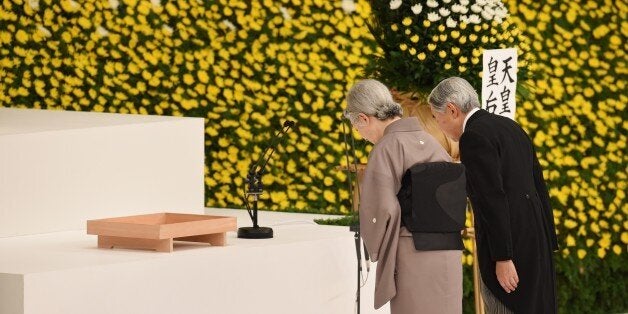 Japanese Emperor Akihito (R) and Empress Michiko (L) bow before the altar during an annual memorial service for war victims i