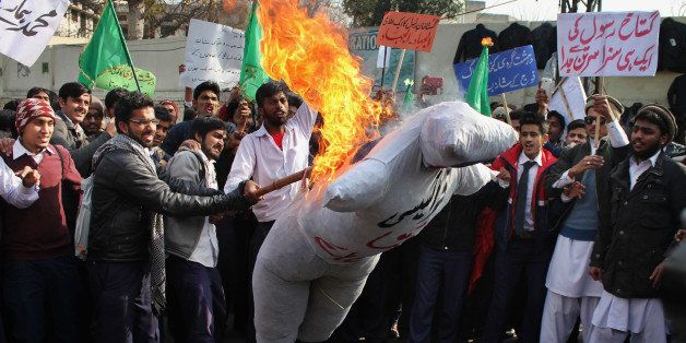 LAHORE, PUNJAB, PAKISTAN - 2015/01/24: Pakistani students of (Punjab Polytechnic Institute ) burn an effigy of French cartoonists during a protest against publications of blasphemous caricatures in French magazine 'Charlie Hebdo' and showing their hearty devotion to Holy Prophet Muhammad (PBUH) during protest demonstration. Tens of thousands across Afghanistan, Pakistan and Muslim-majority Indian Kashmir took to the streets for southern Asia's biggest protests against satirical magazine Charlie Hebdo's cartoon portrayal of the Prophet Mohammed. (Photo by Rana Sajid Hussain/Pacific Press/LightRocket via Getty Images)