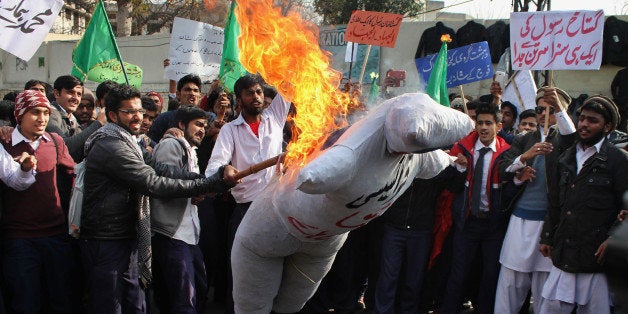 LAHORE, PUNJAB, PAKISTAN - 2015/01/24: Pakistani students of (Punjab Polytechnic Institute ) burn an effigy of French cartoon