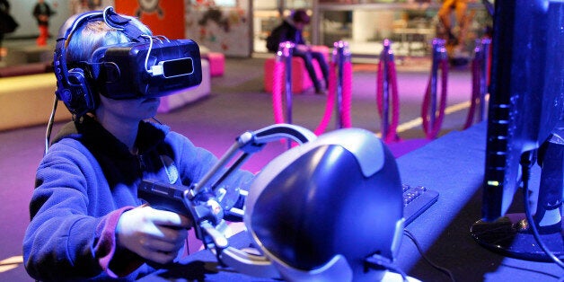 PARIS, FRANCE - DECEMBER 23: A gamer plays a game with the virtual reality head-mounted display 'Oculus Rift' during the 'Noel de Geek' at the Cite des Sciences et de l'industrie on December 23, 2014 in Paris, France. The display transfers the eye movements to the game in real time. 'Noel de Geek' takes place from December 23, 2014 till January 04, 2015. (Photo by Chesnot/Getty Images)