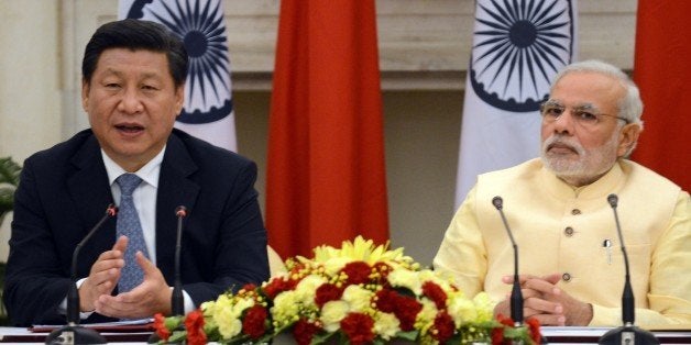 Chinese President Xi Jinping (L) speaks as Indian Prime Minister Narendra Modi looks on as they issue a joint statement in New Delhi on September 18, 2014. India's prime minister expressed concern to China's visiting President Xi Jinping September 18 about 'incidents' on the two countries' disputed border, as a stand-off between troops at the frontier overshadowed key talks. 'I expressed concern on the incidents on the border and said peace and tranquility on the border is the foundation for good relations,' said Prime Minister Narendra Modi after formal talks with the Chinese leader. AFP PHOTO/RAVEENDRAN (Photo credit should read RAVEENDRAN/AFP/Getty Images)