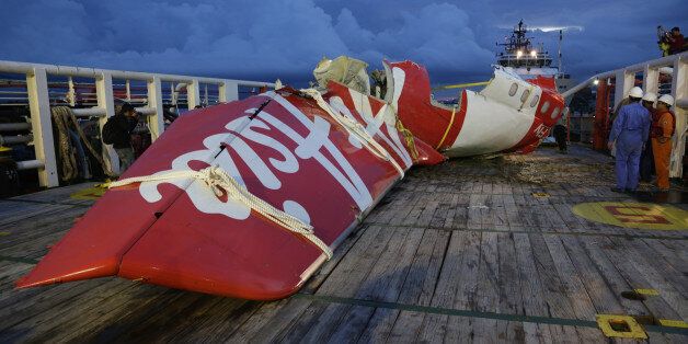 Parts of AirAsia Flight 8501 is seen on the deck of rescue ship Crest Onyx at Kumai port in Pangkalan Bun, Indonesia, Sunday, Jan. 11, 2015. A day after the tail of the crashed AirAsia plane was fished out of the Java Sea, the search for the missing black boxes intensified Sunday with more pings heard. (AP Photo/Achmad Ibrahim)