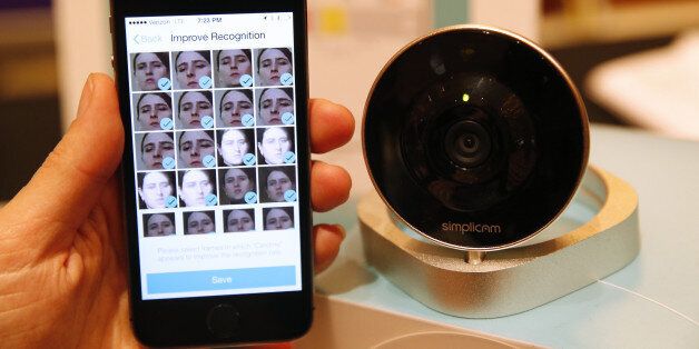 ArcSoft Inc.'s Simplicam monitoring camera with facial recognition, right, is displayed alongside an Apple Inc. iPhone during the 2015 Consumer Electronics Show (CES) in Las Vegas, Nevada, U.S., on Tuesday, Jan. 6, 2015. This year's CES will be packed with a wide array of gadgets such as drones, connected cars, a range of smart home technology designed to make everyday life more convenient and quantum dot televisions, which promise better color and lower electricity use in giant screens. Photographer: Patrick T. Fallon/Bloomberg via Getty Images