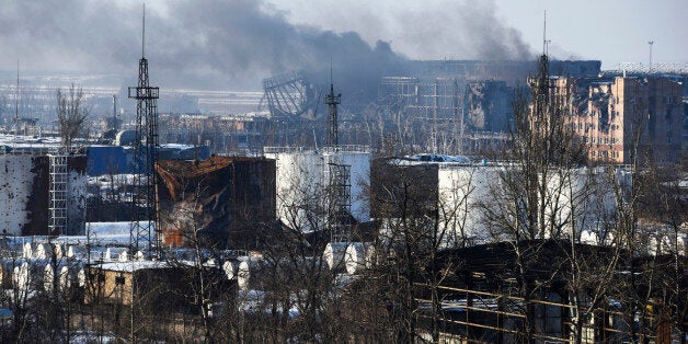 In this Thursday, Jan. 15, 2015 photo, smoke rises over the new terminal of Donetsk airport in Donetsk, Eastern Ukraine. Russ