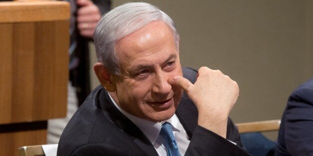 Israeli Prime Minister Benjamin Netanyahu smiles during a Likud party election campaign meeting in Tel Aviv on January 25, 2015 ahead of the March 17 general elections. Netanyahu won early this year another term as leader of the ruling rightwing Likud party ahead of a snap election, easily defeating his lone hard-right challenger. In power since 2009, he will seek to win a third straight term as prime minister and a fourth in total. He served a first stint between 1996 and 1999. AFP PHOTO/MENAHEM KAHANA (Photo credit should read MENAHEM KAHANA/AFP/Getty Images)